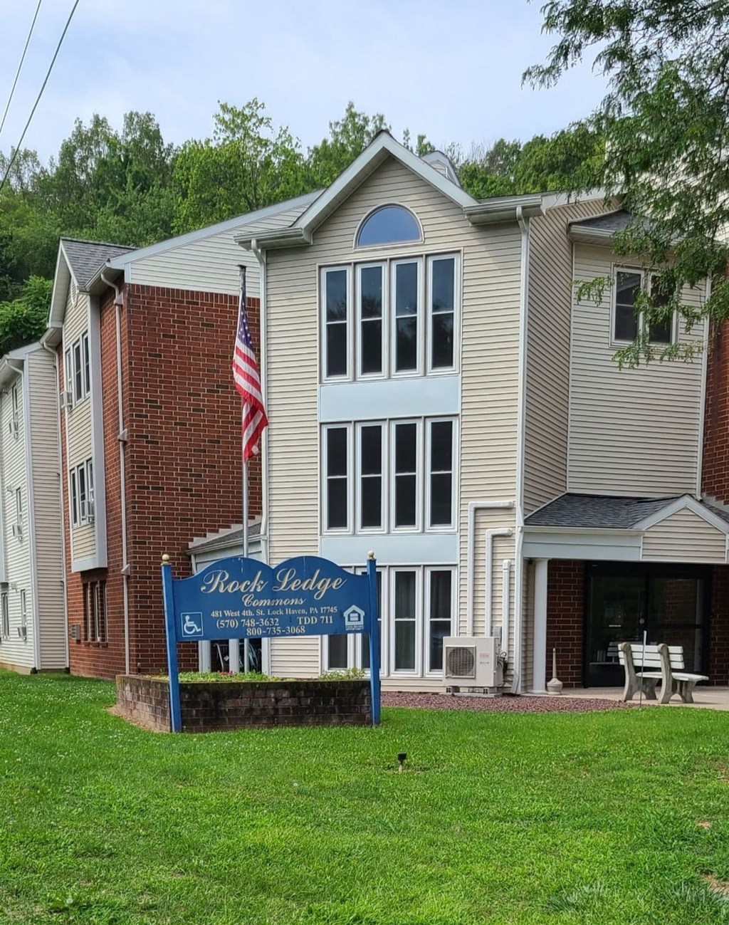 a building with an flag and a sign in front of it