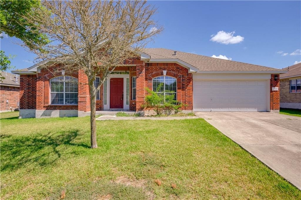 a red brick house with a tree in front of it