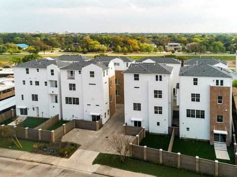 an aerial view of some white and brick apartment buildings