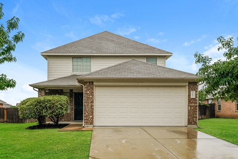 a white house with a white garage door and a green lawn