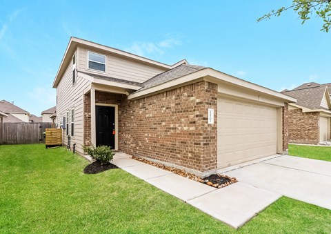 a brick house with a sidewalk in front of it