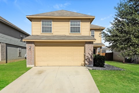 a yellow house with a yellow garage door and a green lawn