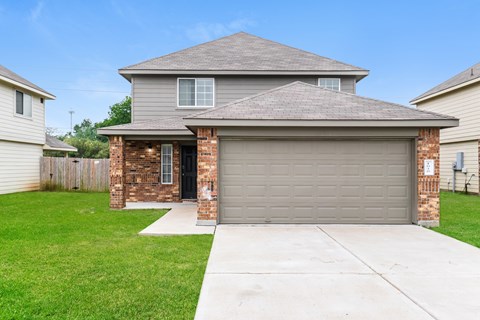 a house with a gray garage door and a lawn