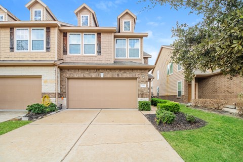 a house with a garage door and a driveway in front of it