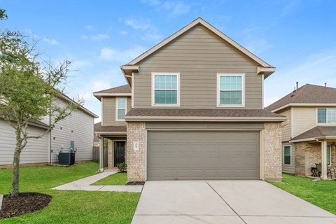 a beige and brown house with a garage door