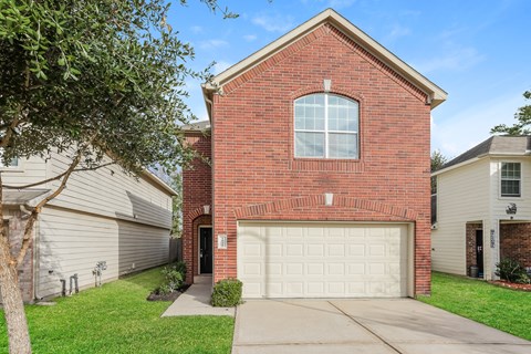 a red brick house with a white garage door