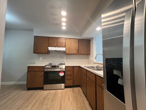 a kitchen with wooden cabinets and stainless steel appliances