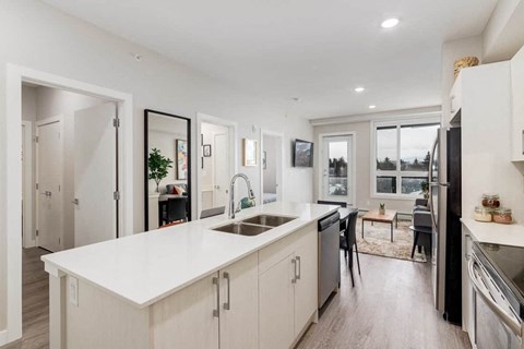 A modern kitchen with white cabinets and a large island.