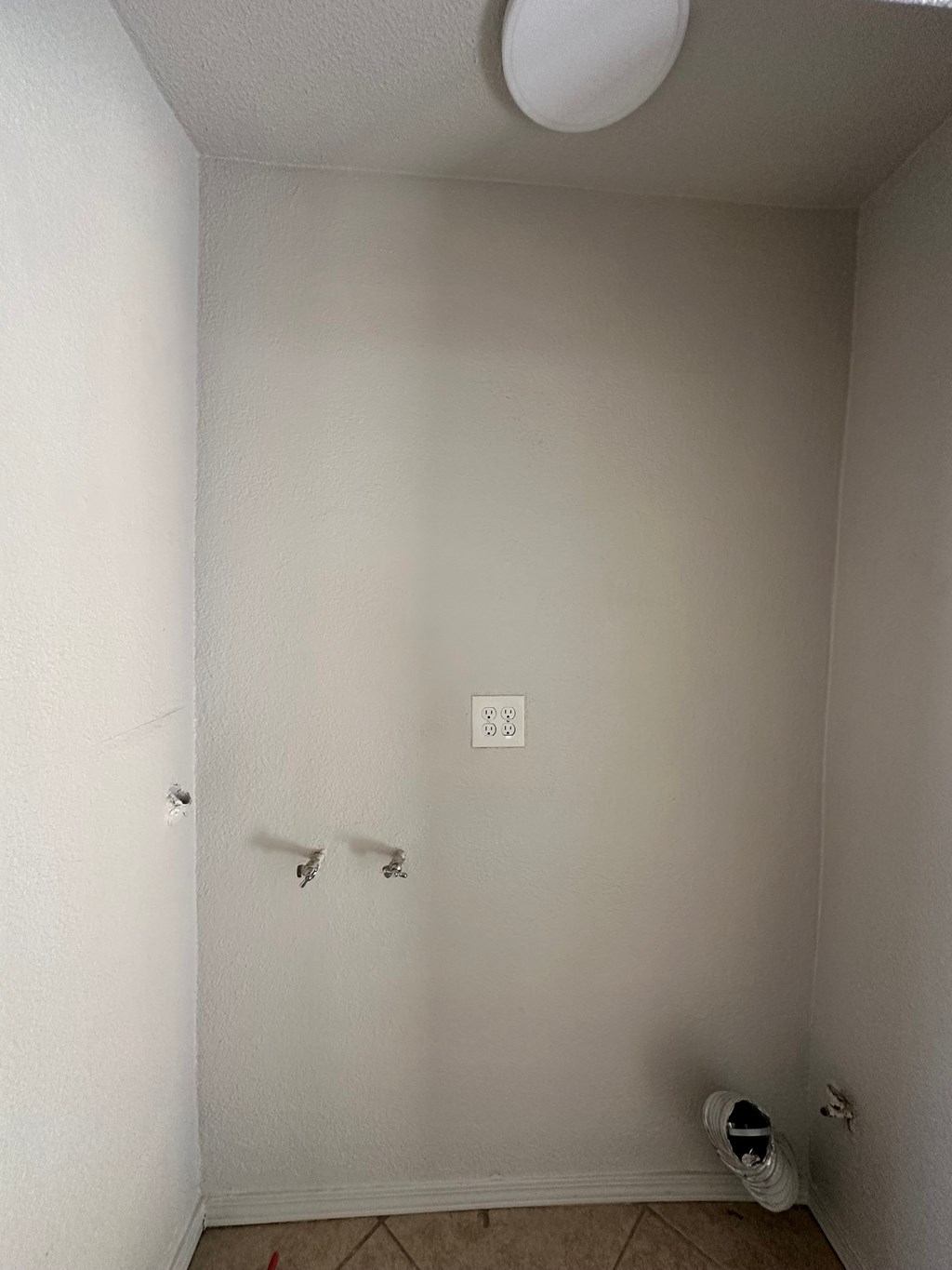 an empty room with a white wall and a shoe on the floor