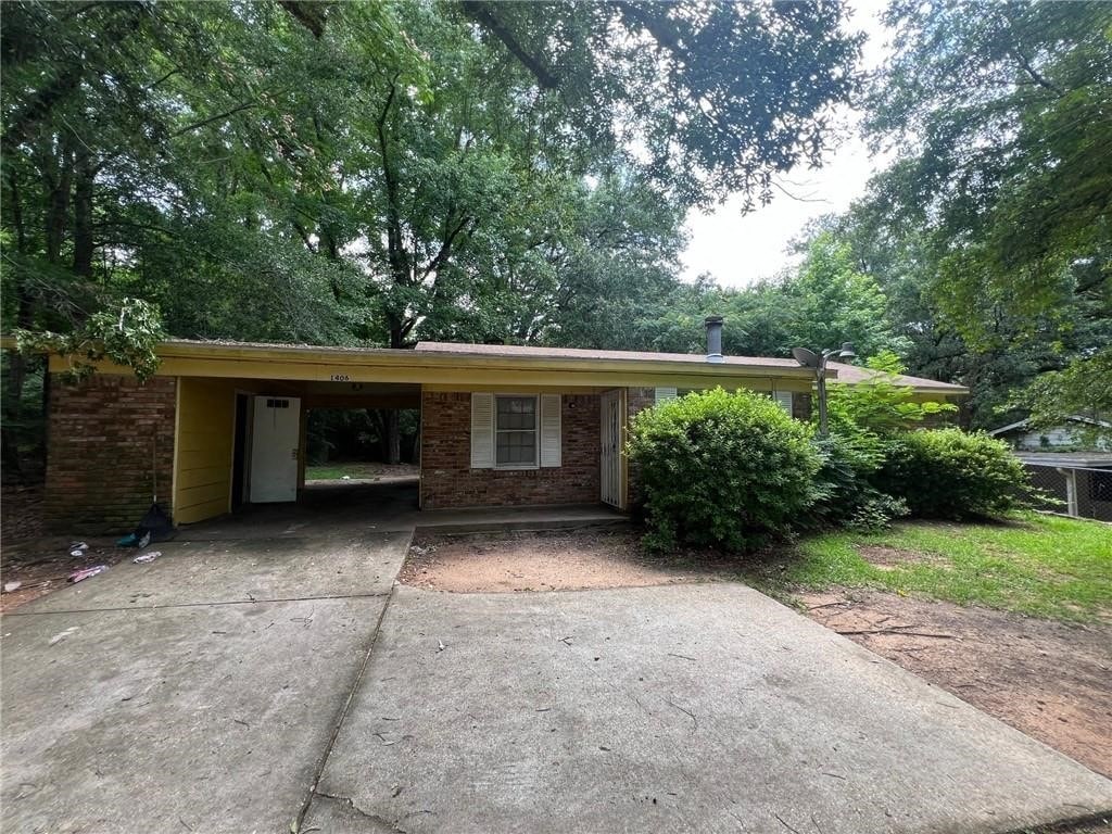 a small brick house with a large yard and a driveway