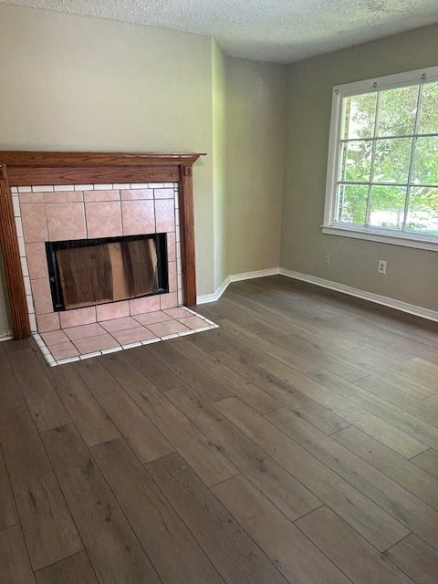an empty living room with a fireplace and wooden floors