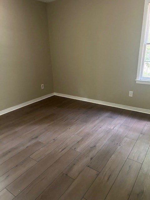an empty room with wooden floors and a window