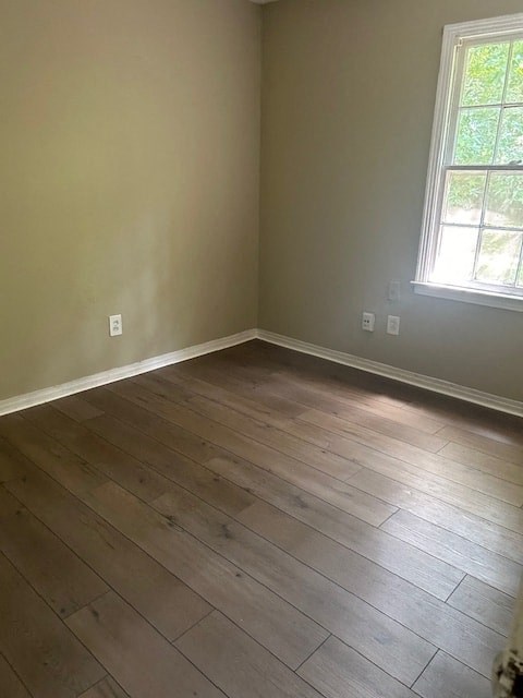 an empty room with wooden floors and a window