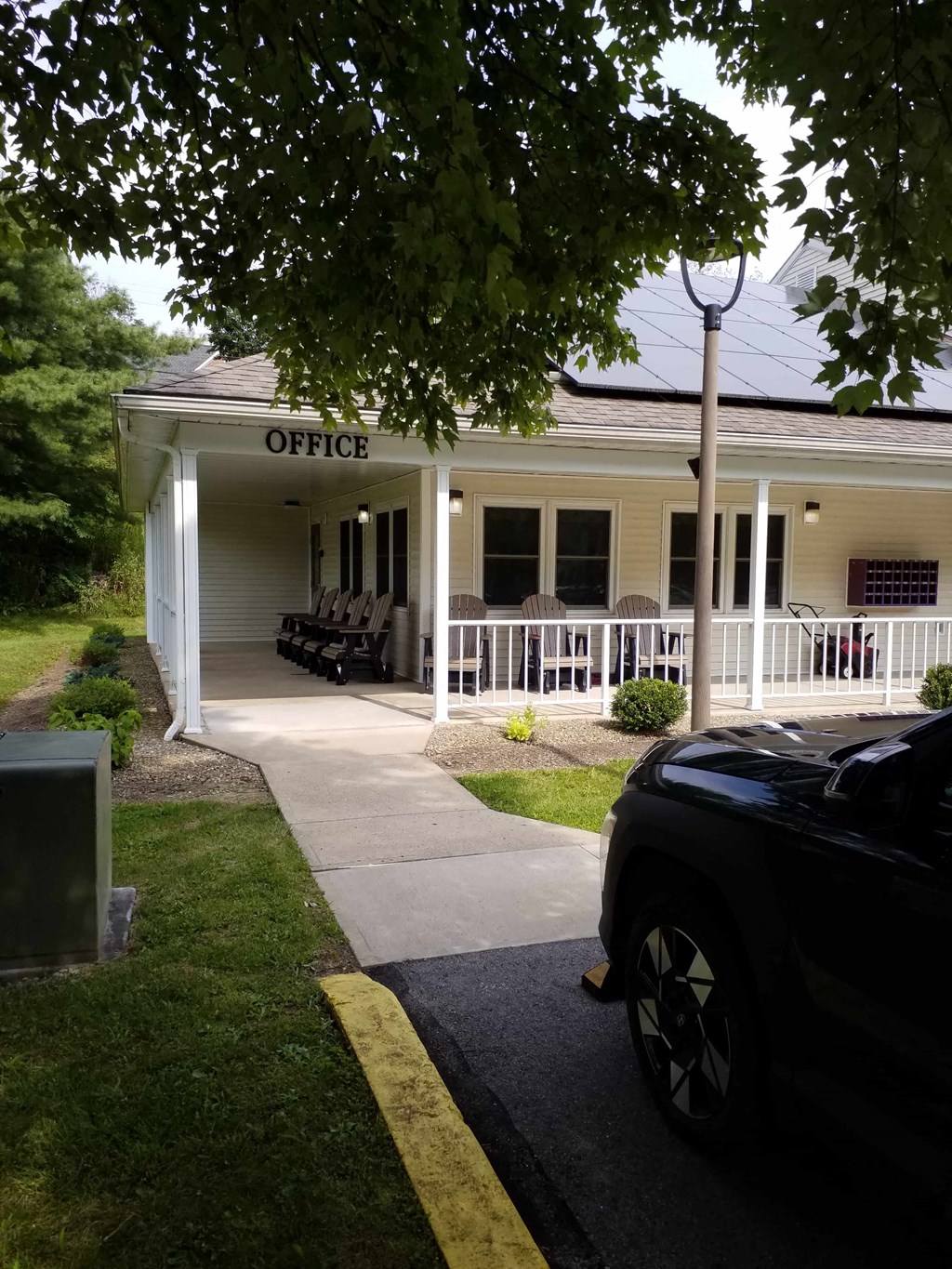 a building with a porch and a car parked in front of it