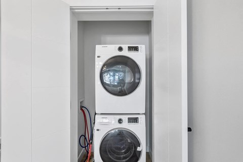 a white washer and dryer in a white closet