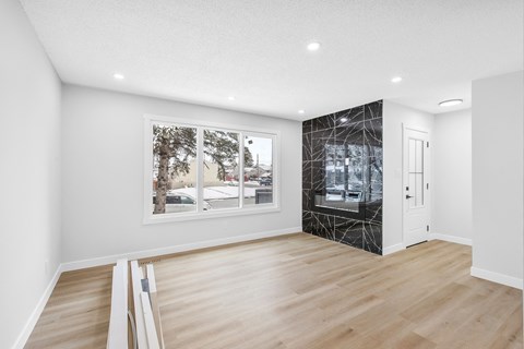 a living room with white walls and a window and a glass closet