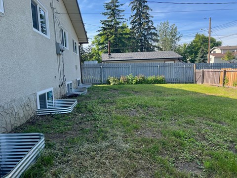 a backyard with a fence and a house and some steps