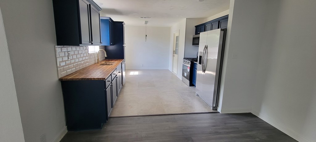 A kitchen with black cabinets and a white tile backsplash.