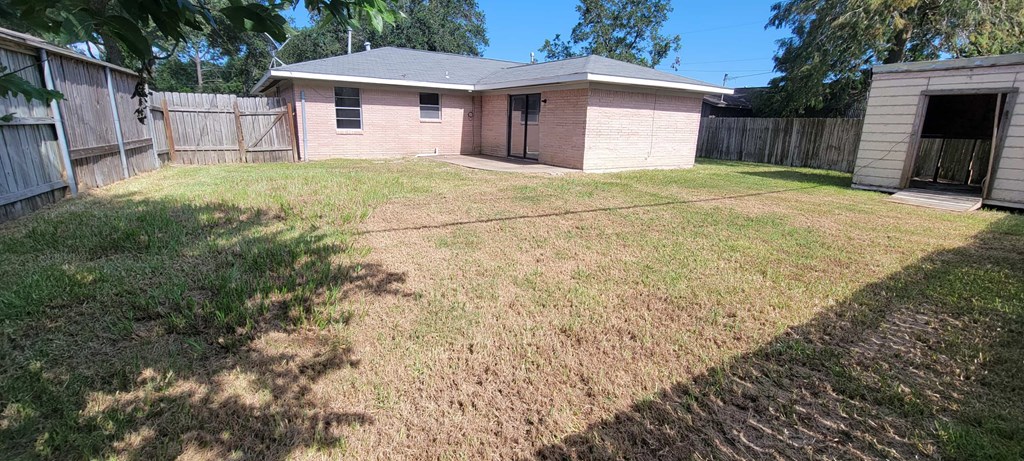 A backyard with a shed and a house.