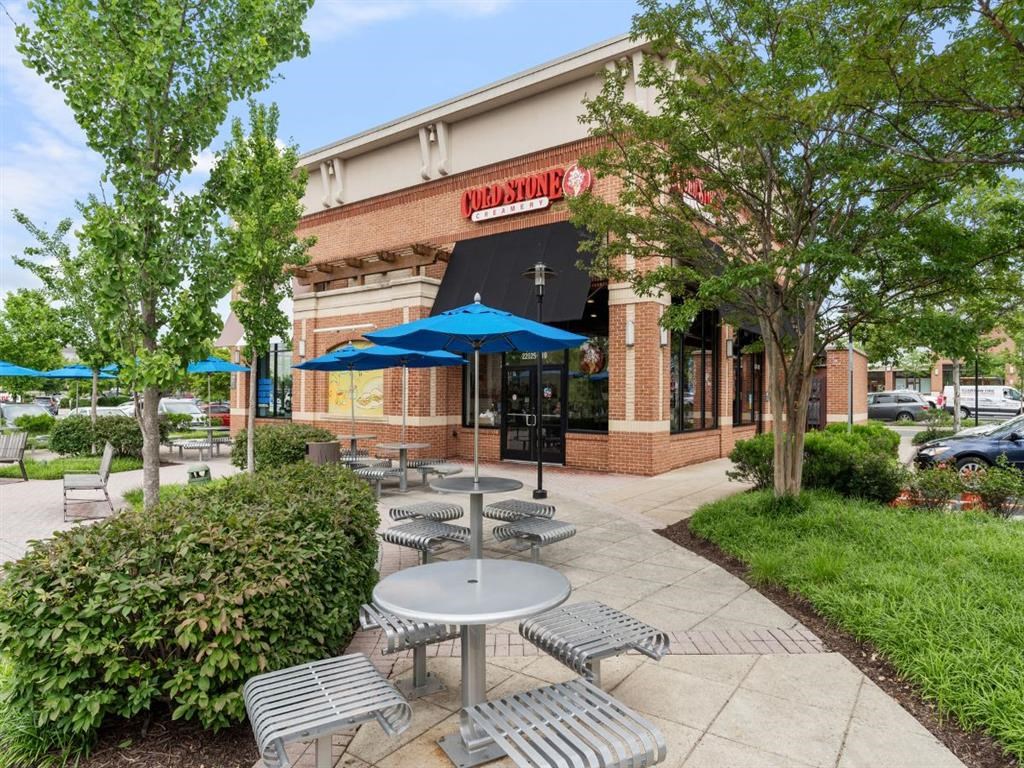 a patio outside of a restaurant with tables and umbrellas