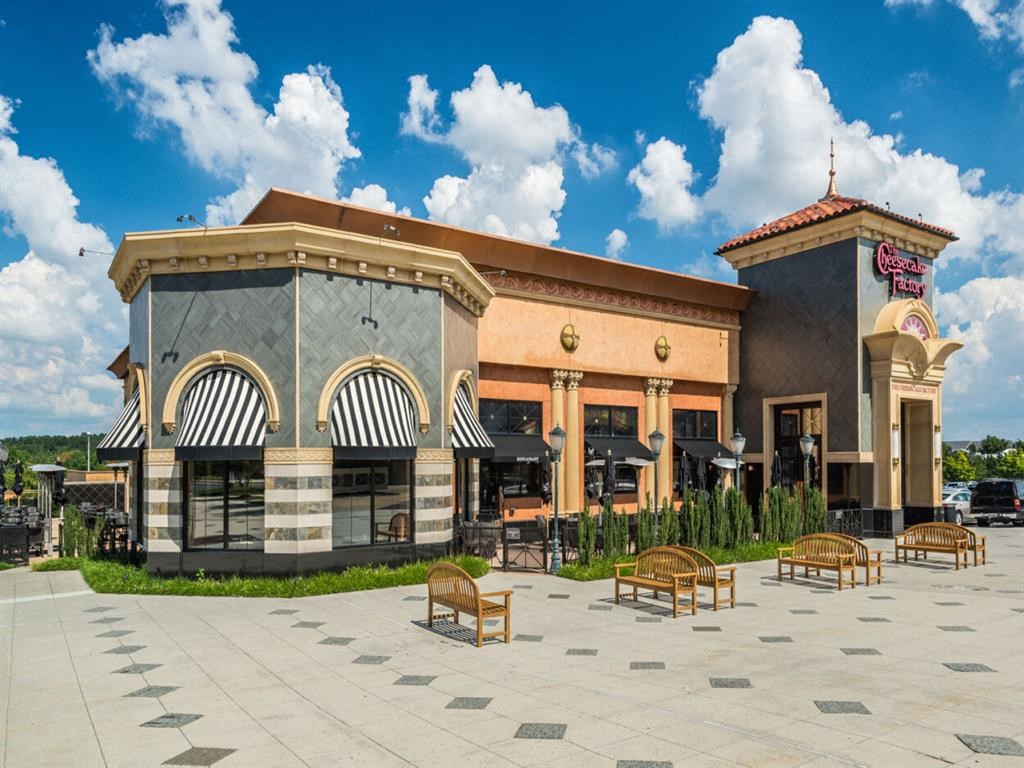 a rendering of the front of a building with tables and benches