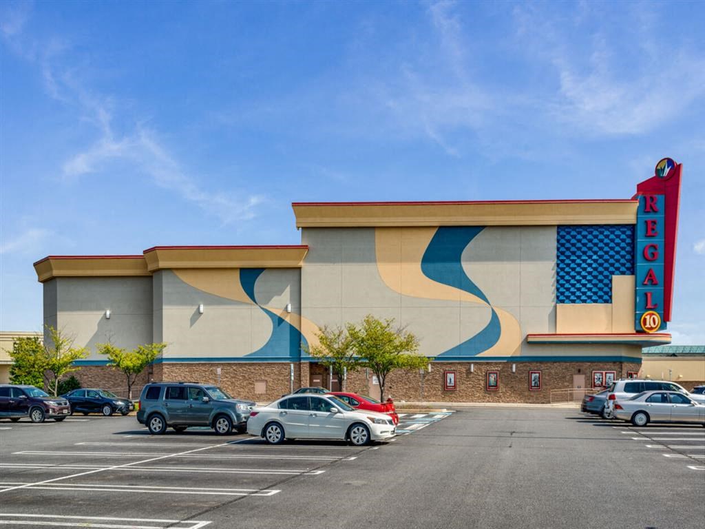an empty parking lot in front of a building with a sign for a movie theater