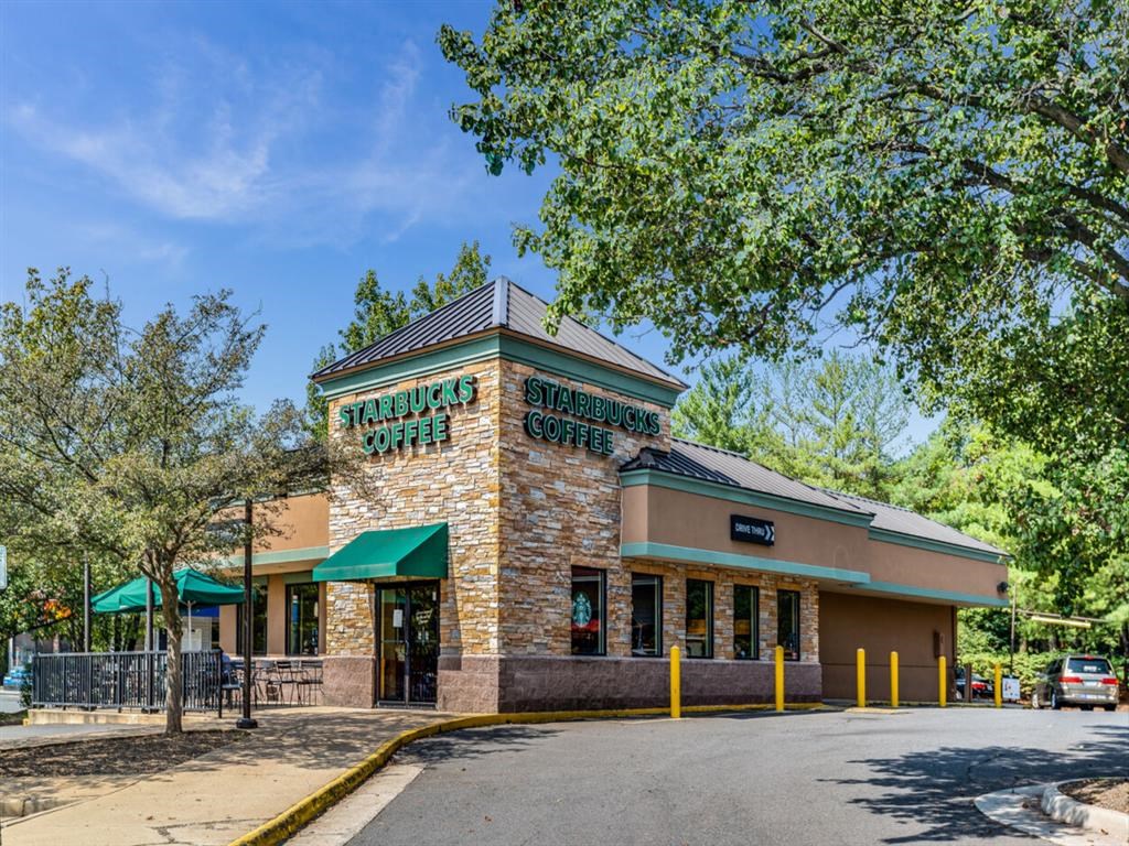the facade of a restaurant with a street and trees