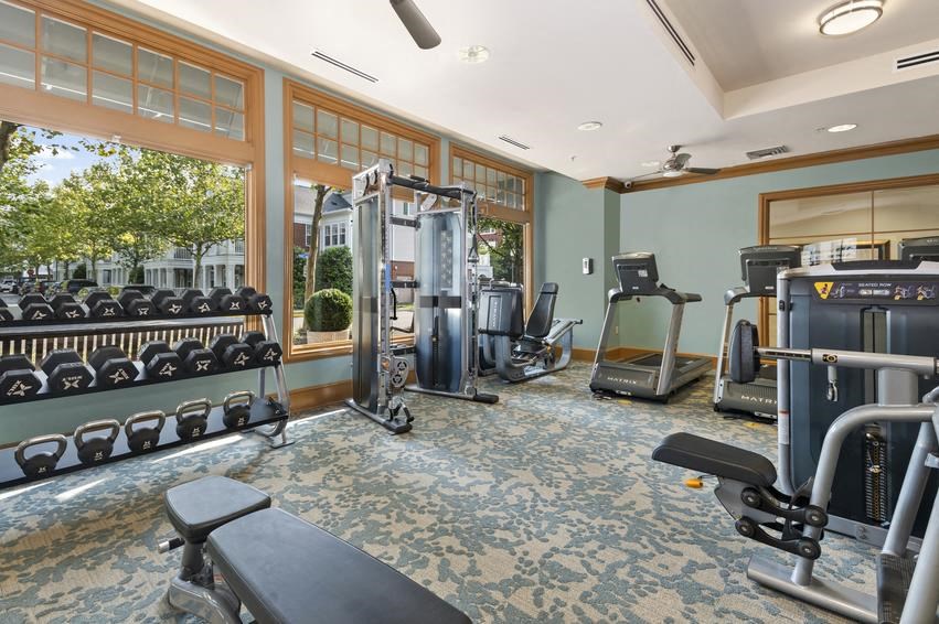 a gym with a lot of exercise equipment and a window