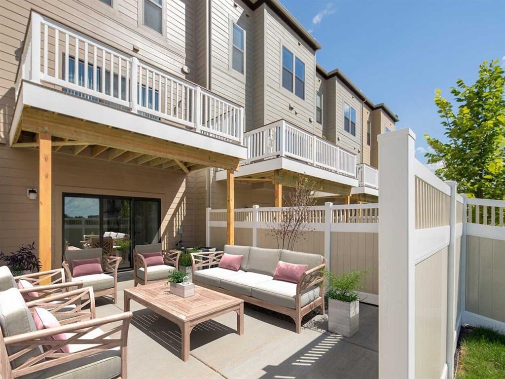 a covered patio with furniture in front of a house