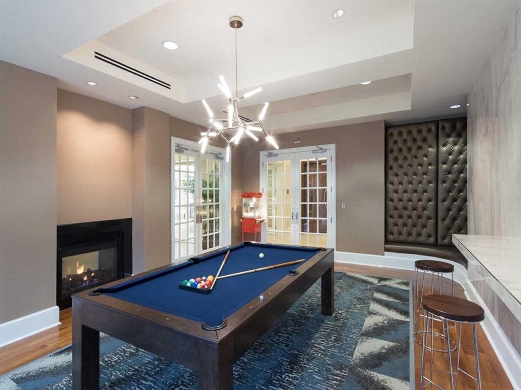 a pool table in a living room with a fireplace