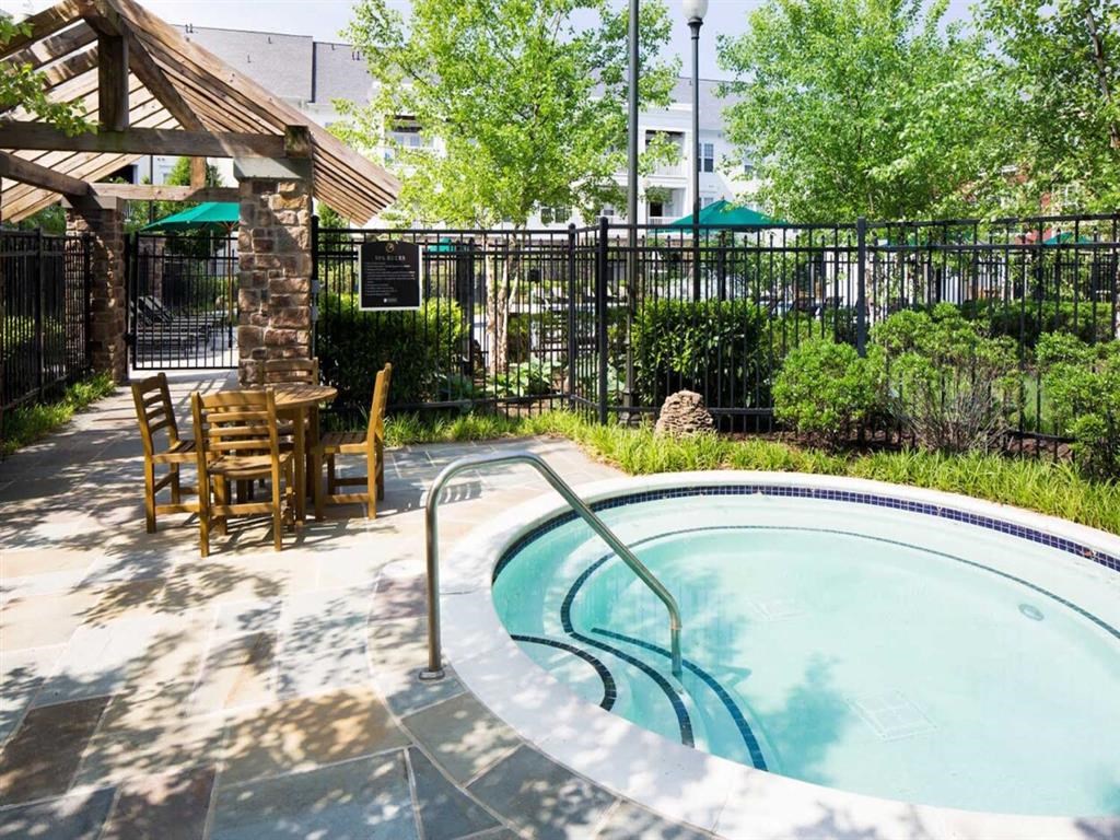 a pool with chairs and a table next to a fence