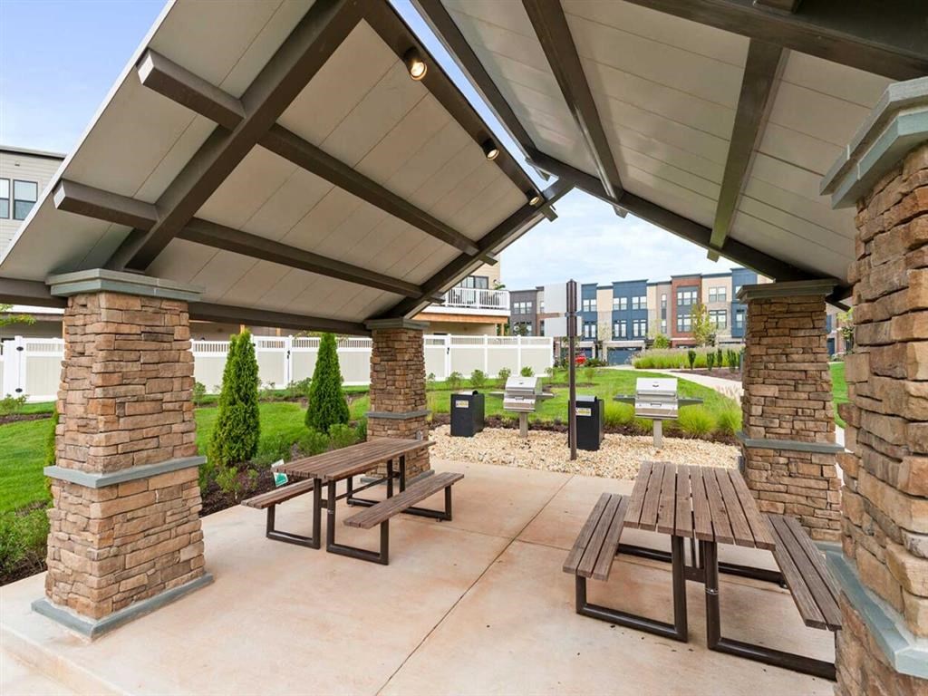 a picnic area with benches and a building in the background
