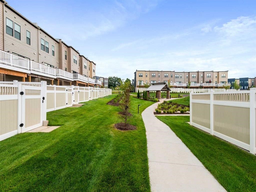 a row of apartments with grass and a sidewalk