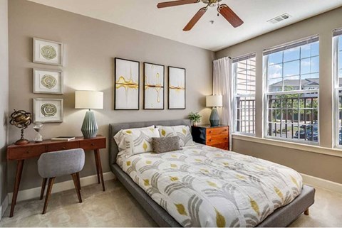 a bedroom with a bed and a ceiling fan