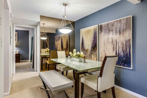 a dining room with a glass table and chairs