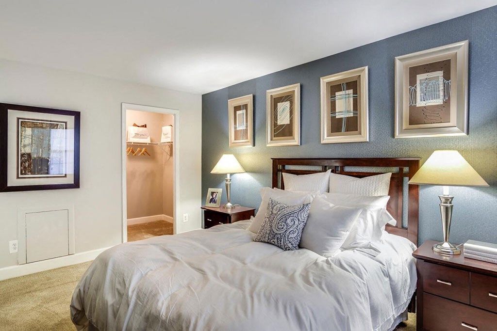 a bedroom with a bed and some pictures on the wall