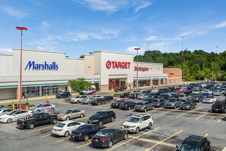 a parking lot filled with cars in front of a shopping mall