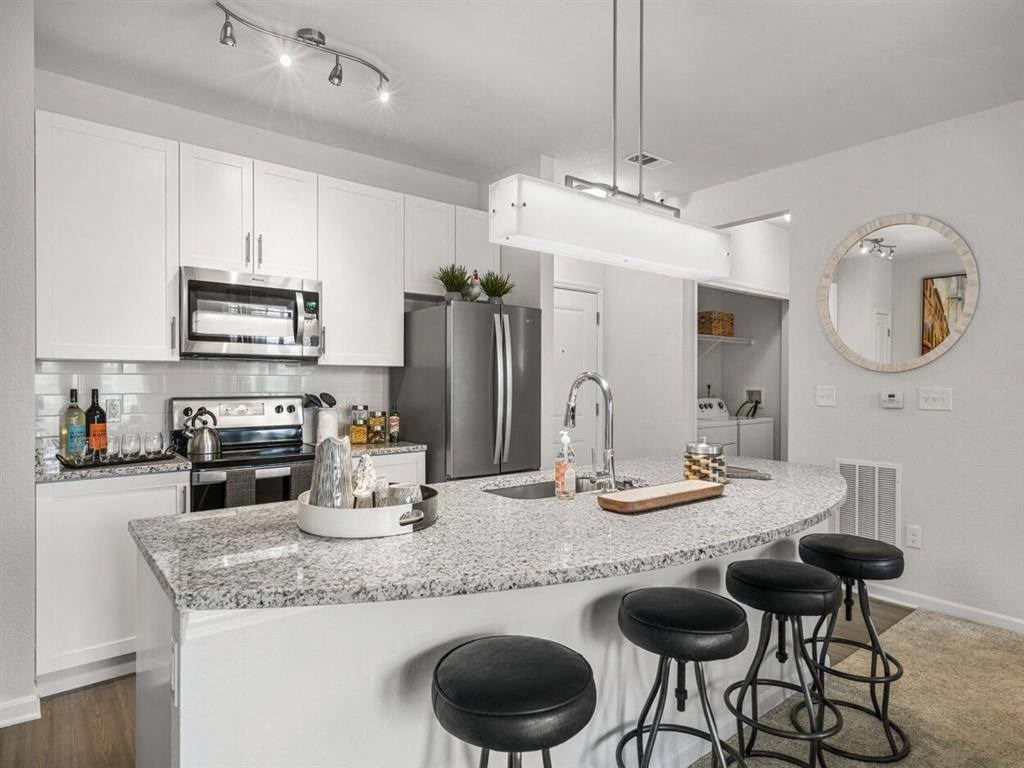 a kitchen with an island with black stools
