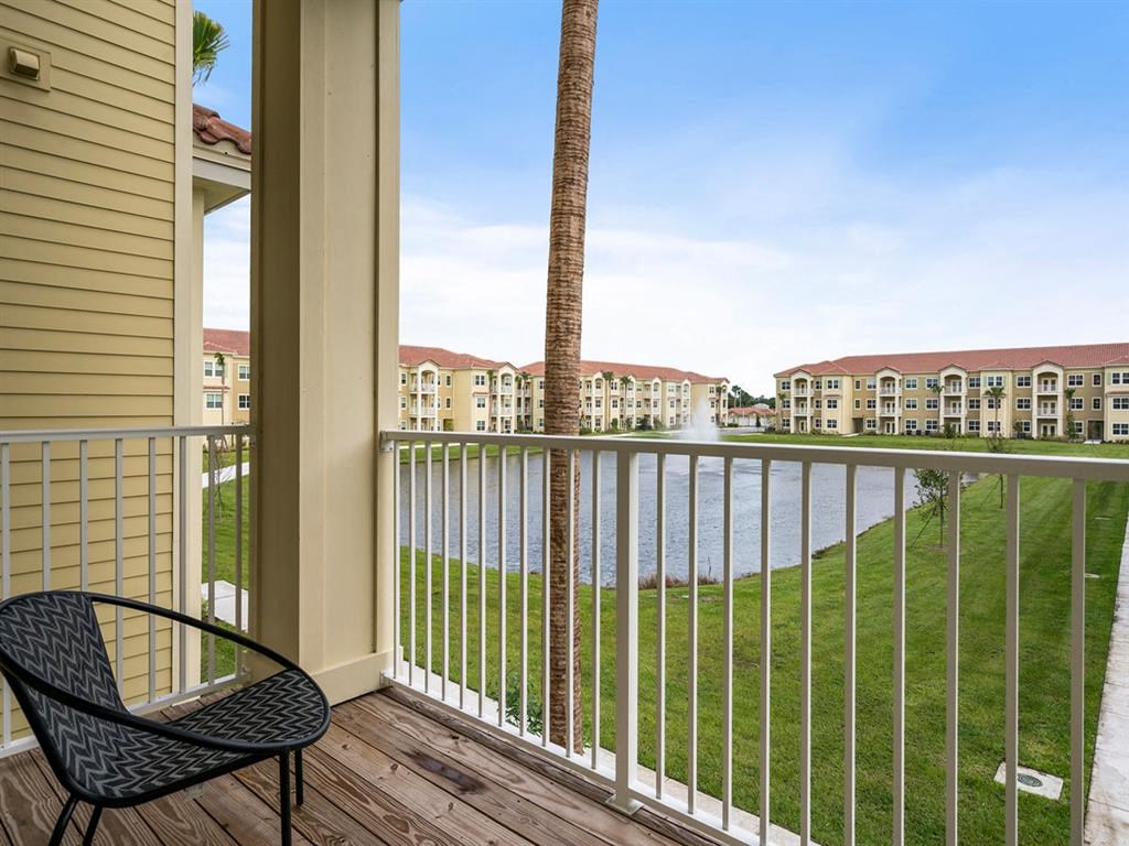 a balcony with a chair and a palm tree