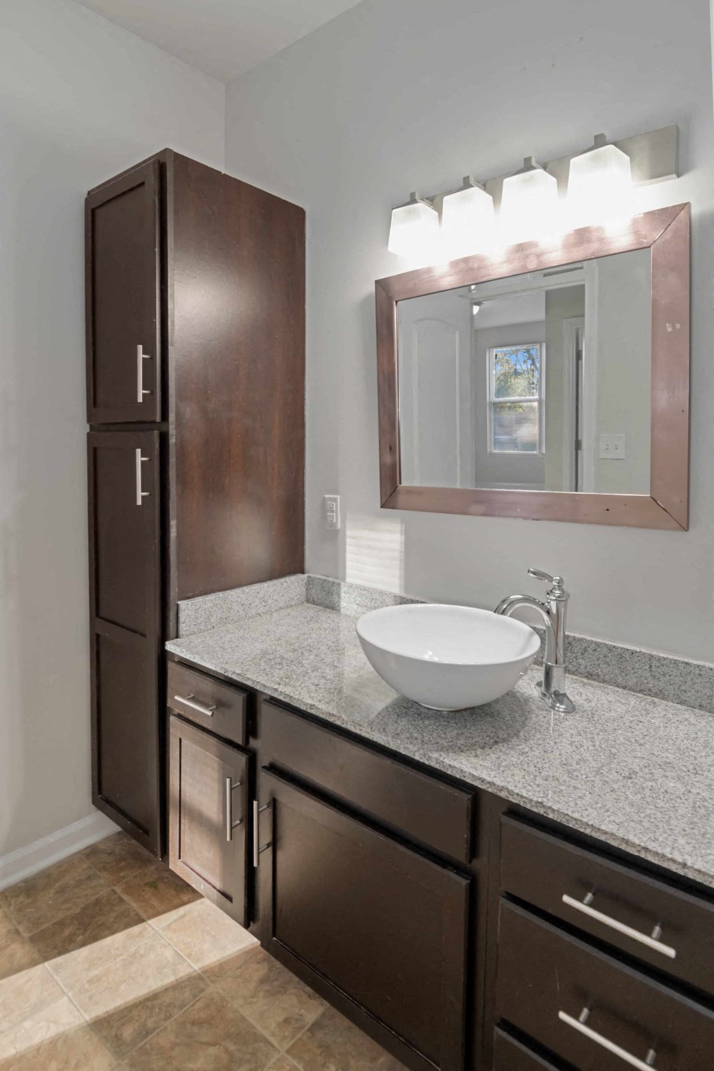 A bathroom with a sink, mirror, and cabinets.