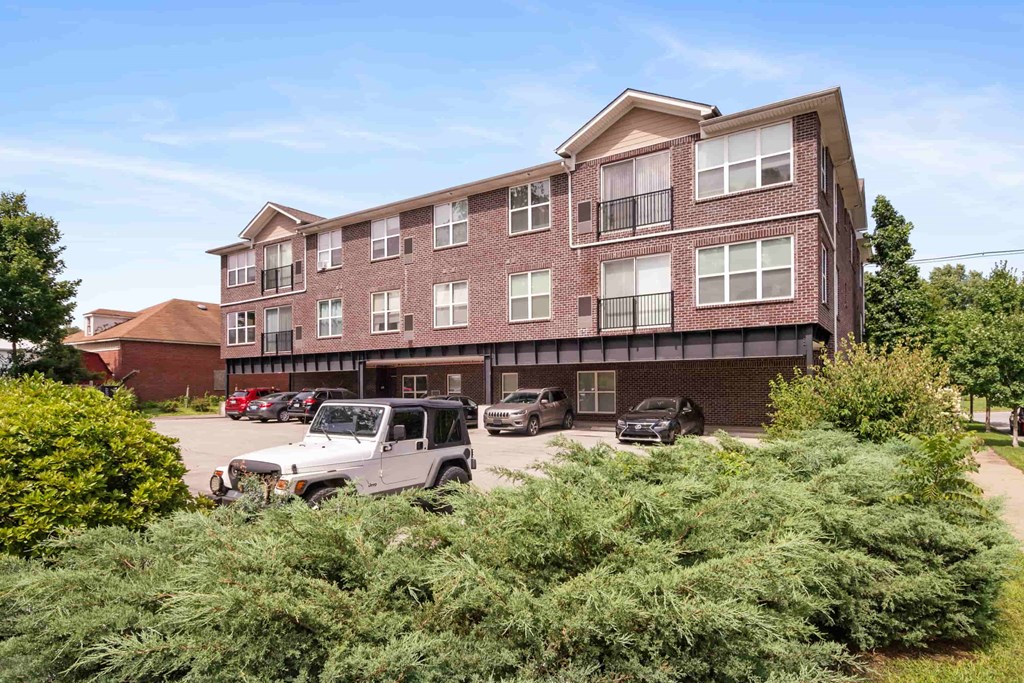A large brick building with a parking lot in front of it.