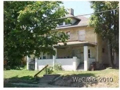 a house with a porch and a tree