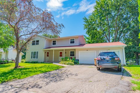 A house with a car parked in front.