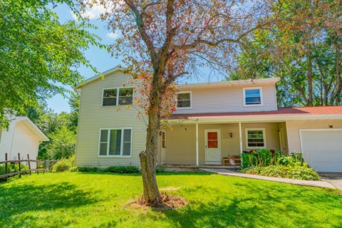 A house with a tree in front of it.