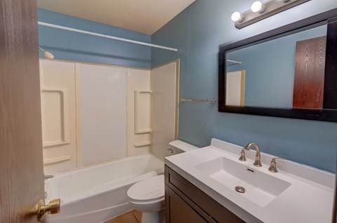 A bathroom with blue walls and a white sink.