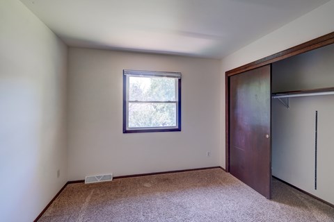 A room with a window and a brown door.