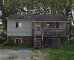 A house with a balcony and a ladder outside.