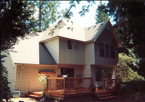 A house with a grey roof and a brown deck.