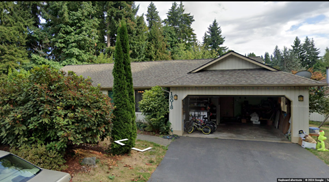 A house with a garage and a car parked in front.