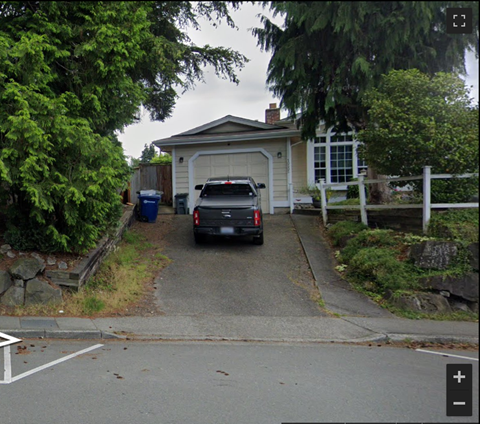 A car is parked in front of a garage.